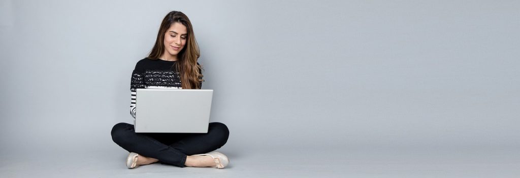 woman on floor holding laptop